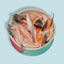 individual salmon bellies in dog food bowl, blue background